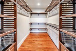 A walk in closet with wooden shelves and baskets