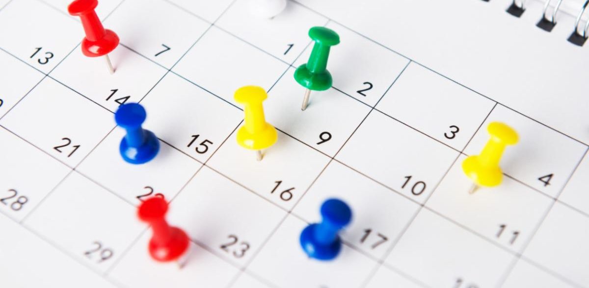 Calendar with push pins in the dates
