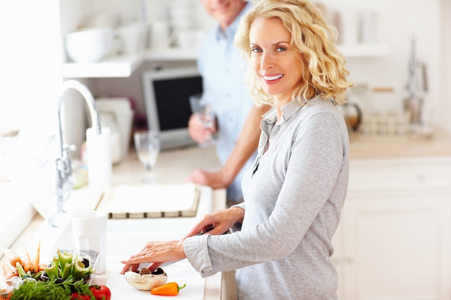 A woman cooking in the kitchen cutting vegetables