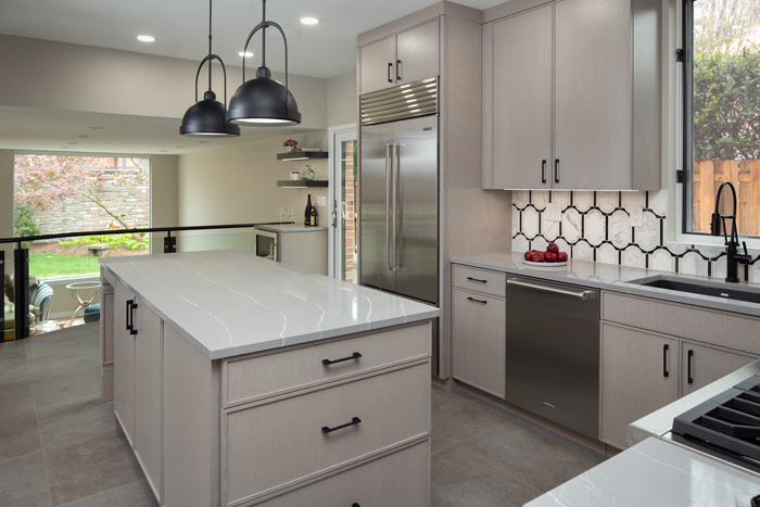 A kitchen with gray cabinets, white counters and black lighting