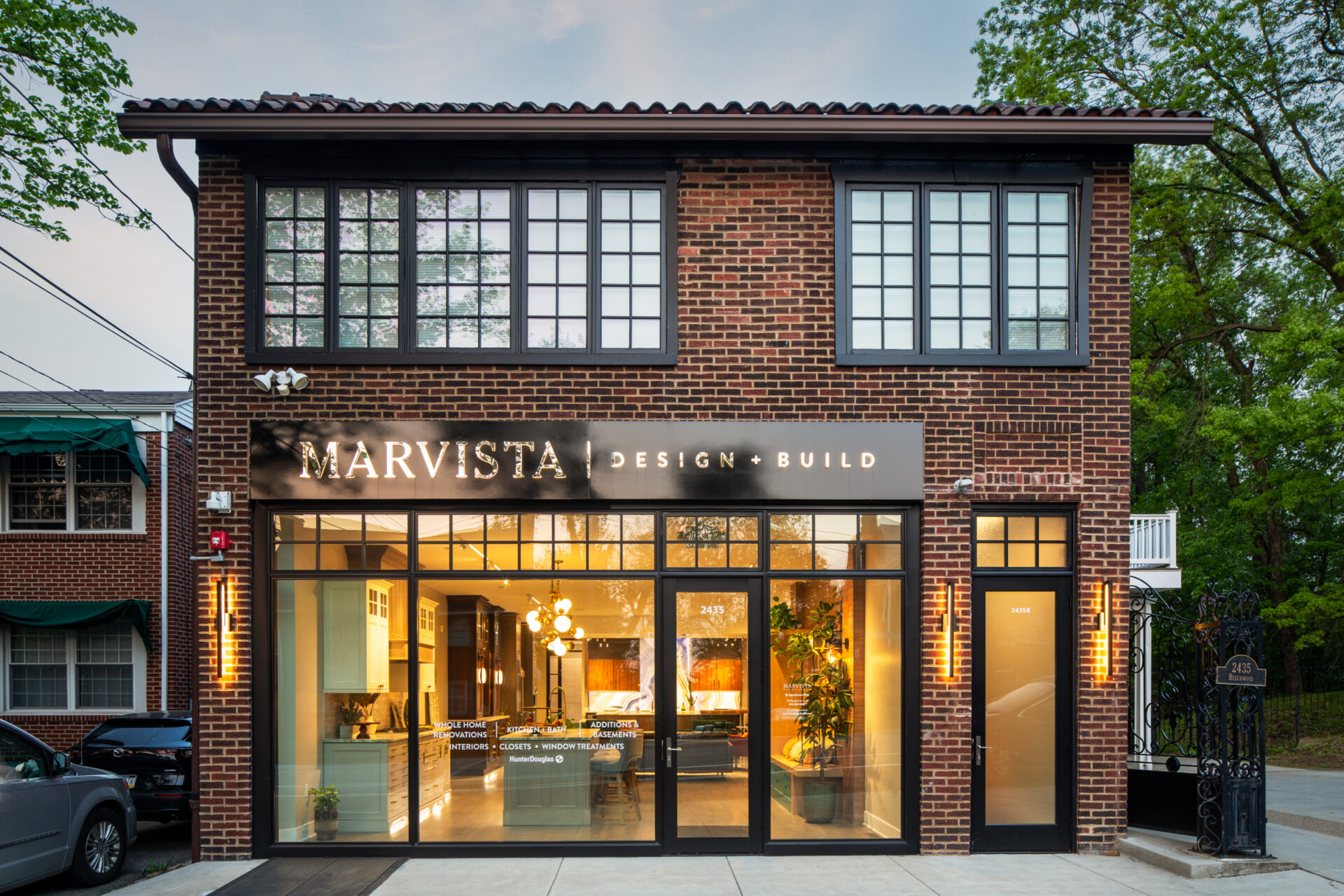 Marvista location. Small two-story brick building with black-framed windows and well-lit showroom inside first floor.