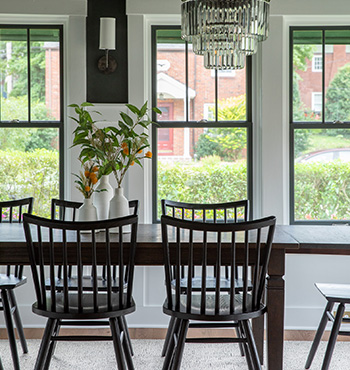Renovated dining area with black framed windows and dark dining set.
